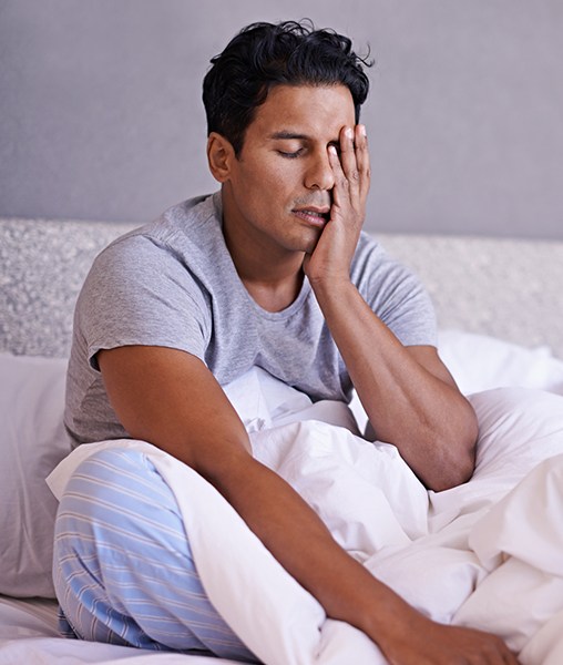 Frustrated man in need of sleep apnea treatment waking feeling unrested
