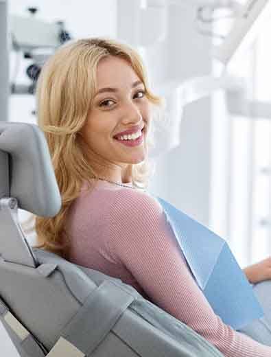 Woman smiling while sitting in dental chair