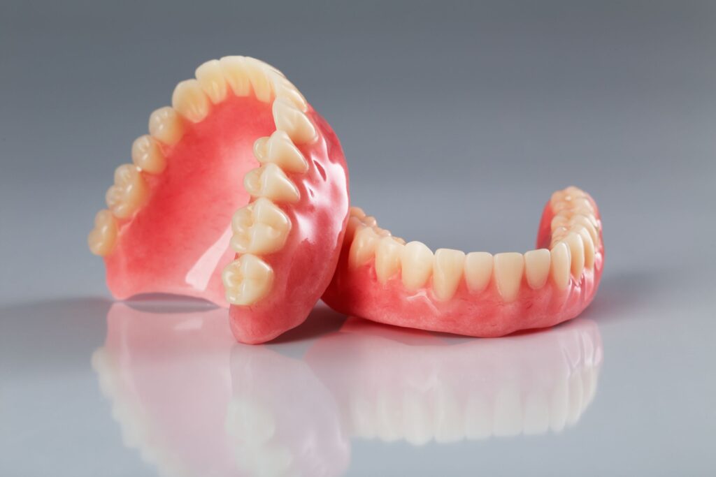 Full set of dentures on reflective gray surface